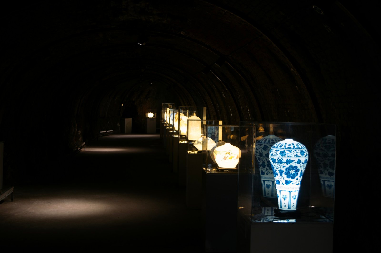 Blue-and-white porcelain vases in illuminated museum display cases